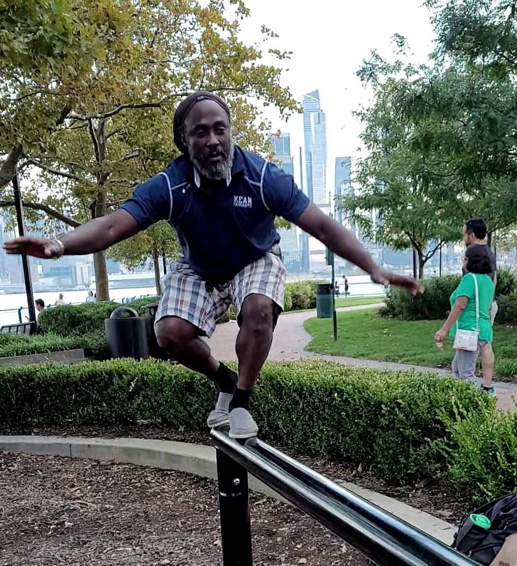 Irvin Charleston balancing on a rail beside the waterfront